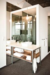 a bathroom with two sinks and a large mirror at Hotel Daniel Vienna - Smart Luxury Near City Centre in Vienna