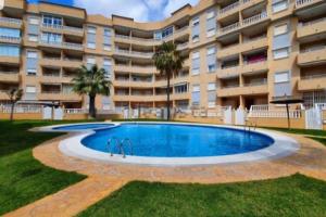 einem Pool vor einem großen Apartmenthaus in der Unterkunft Apartamento muy cerca del mar. in Arenales del Sol