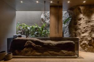a large stone tub in a room with plants at Acro Suites - A Wellbeing Resort in Agia Pelagia