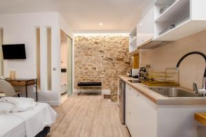 - une cuisine avec évier et un lit dans une chambre dans l'établissement Curcumelli Luxury Suites - ΠΟΡΤΟΝΙ 1, à Corfou
