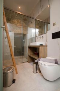 a bathroom with a tub and a toilet and a sink at Curcumelli Luxury Suites - ΠΟΡΤΟΝΙ 1 in Corfu Town