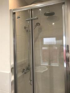 a shower with a glass door in a bathroom at Beckenham Ambleside in Elmers End