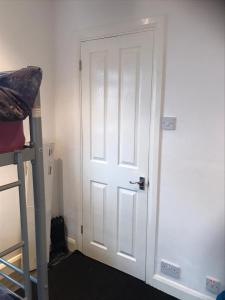 a white door in a room next to a bed at Beckenham Ambleside in Elmers End