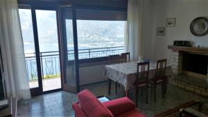 a living room with a fireplace and a table and chairs at Villetta Vella Miralago by Garda Domus Mea in Tremosine Sul Garda