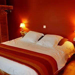 a large bed in a bedroom with a red wall at Le Ranch des Lacs in Augne