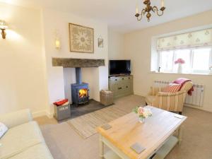 a living room with a table and a fireplace at Lovely 2-Bed Cottage in Blaenau Ffestiniog in Blaenau-Ffestiniog
