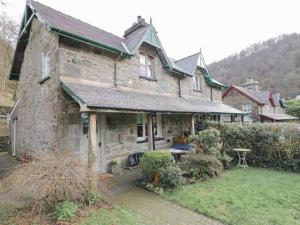 an old stone house with a garden in front of it at Lovely 2-Bed Cottage in Blaenau Ffestiniog in Blaenau-Ffestiniog