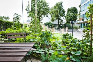 a garden with a bench and lots of plants at Hotel Daniel Vienna - Smart Lifestyle Near City Centre in Vienna
