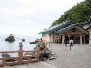 伊勢市にあるげすとはうす伊勢二見の海辺の建物を通り過ぎた二人