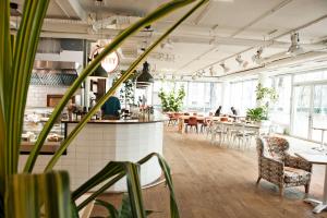 un ristorante con tavoli, sedie e piante di Hotel Daniel Vienna - Smart Luxury Near City Centre a Vienna