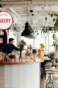 a man preparing food at a counter in a restaurant at Hotel Daniel Vienna - Smart Lifestyle Near City Centre in Vienna