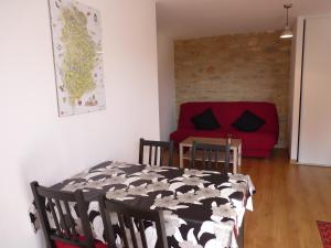 - un salon avec une table et un canapé rouge dans l'établissement Aux Pierres de Nozières, à Gramat