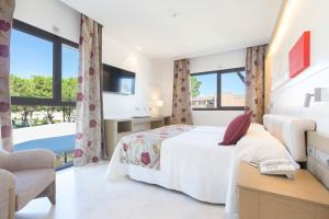 a hotel room with a bed and a tv at Hipotels Barrosa Garden in Chiclana de la Frontera