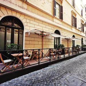 a row of tables and umbrellas outside of a building at Rome River Inn in Rome