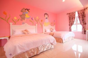 1 dormitorio con 2 camas y un mural de Disney en la pared en Decoupage Manor, en Jiaoxi