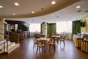 ein Restaurant mit Tischen und Stühlen in einem Zimmer in der Unterkunft Voznesensky Hotel in Jekaterinburg