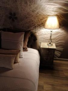 1 dormitorio con 1 cama y 1 lámpara en una mesa en Le Charm'en Gîte, en Tournai