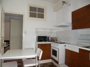 a kitchen with white counters and a stove top oven at Appartement Kalliste in Bastia