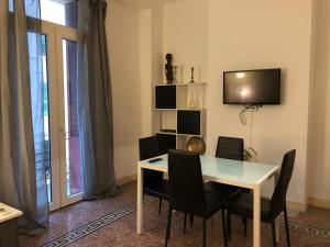 a dining room with a table and chairs and a television at Kalliste - Appartement centre ville tout équipé in Bastia