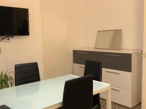 een vergaderruimte met een tafel en stoelen en een tv bij Kalliste - Appartement centre ville tout équipé in Bastia