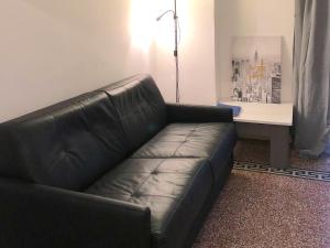 - un canapé en cuir noir dans un salon avec une table dans l'établissement Kalliste - Appartement centre ville tout équipé, à Bastia