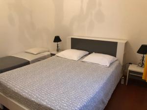 2 camas en una habitación pequeña con 2 lámparas en Kalliste - Appartement centre ville tout équipé en Bastia