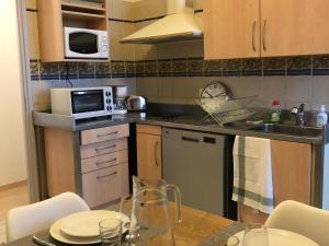 a small kitchen with a table and a microwave at Casella - Appartement centre ville tout équipé in Bastia