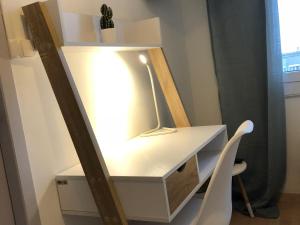 une coiffeuse blanche avec un miroir et une chaise dans l'établissement Casella - Appartement centre ville tout équipé, à Bastia