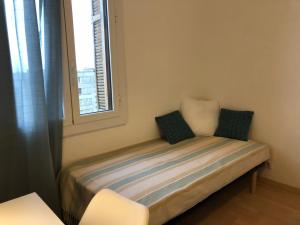 a small bed in a room with a window at Casella - Appartement centre ville tout équipé in Bastia