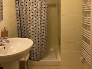 a bathroom with a sink and a shower curtain at Appartement Casella in Bastia