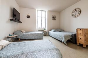 - une chambre avec 3 lits et une horloge murale dans l'établissement Studio centre ville avec parking privé, à Cholet