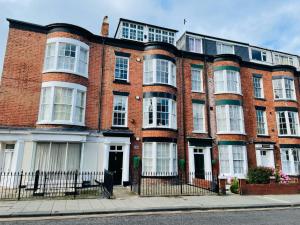 a large red brick building with white windows at Marine Sands - luxury apartment in Scarborough