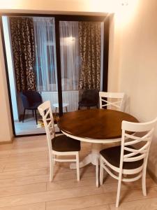 a dining room with a wooden table and chairs at APARTAMENT PARK in Brăila