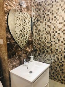 uma casa de banho com um lavatório e um espelho em forma de coração em APARTAMENT PARK em Braila