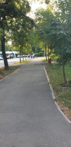 um caminho em um parque com árvores e pessoas andando em APARTAMENT PARK em Braila