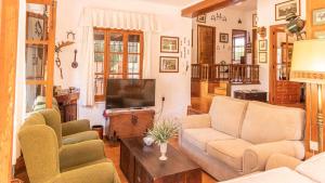 ein Wohnzimmer mit Sofa und Fernseher in der Unterkunft Casa Rural Santa Ana in Marchena