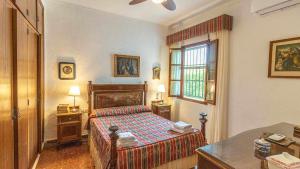 ein Schlafzimmer mit Bett, Schreibtisch und Fenster in der Unterkunft Casa Rural Santa Ana in Marchena + 37 Fotos