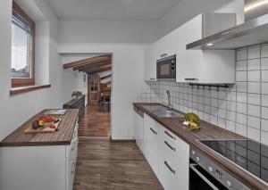 a kitchen with white cabinets and a wooden floor at Hotel Goldener Greif in Kitzbühel