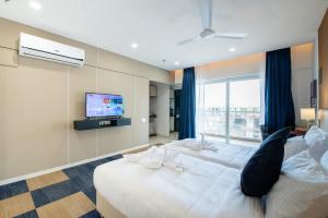 una camera d'albergo con due letti e una televisione di StayBird - B Suite, Business Hotel, Kharadi a Pune