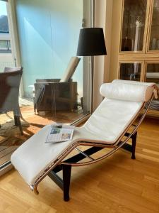 einen weißen Stuhl im Wohnzimmer mit Klavier in der Unterkunft At Rinaldi 22 in Davos