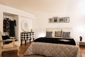 a bedroom with a large bed and a chair at Idyllia - lovely Colosseum loft apartment in Rome