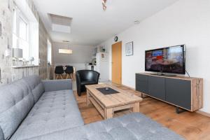 a living room with a couch and a flat screen tv at Ferienwohnung im Haus Hafenlicht in Neuharlingersiel