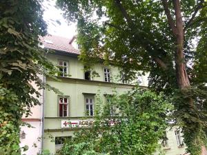 ein weißes Gebäude mit roten Fenstern und Bäumen in der Unterkunft "goethezimmer" Ferienwohnungen Am Schloss in Weimar