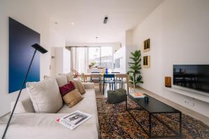 uma sala de estar com um sofá e uma televisão em Smartflats - River View Ghent em Gante