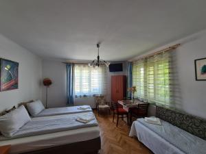 Sala de estar con 2 camas y mesa en Aurora vendégház, en Sfântu-Gheorghe