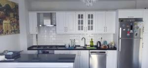 a kitchen with white cabinets and a stainless steel refrigerator at Sapanca villa in Sapanca