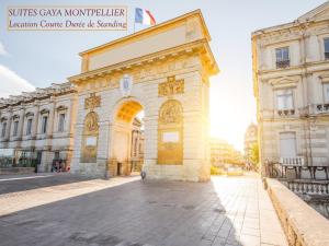 a building with an arch in the middle of a street at Rare Loft vue sur les toits - Suites Gaya Centre Historique in Montpellier