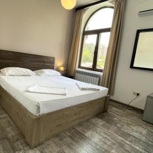 a bedroom with a large bed and a window at City Centre Hotel By Picnic in Yerevan