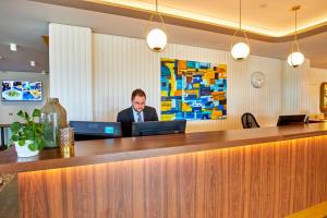a man sitting at a bar with a laptop at Fosshotel Stykkisholmur in Stykkishólmur