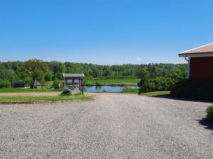 a gravel driveway with a lake and a gazebo at Sjötorp säteri & stugby in Larv